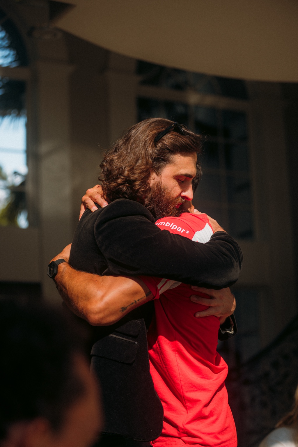 Two men sharing an embrace at an LCL gathering