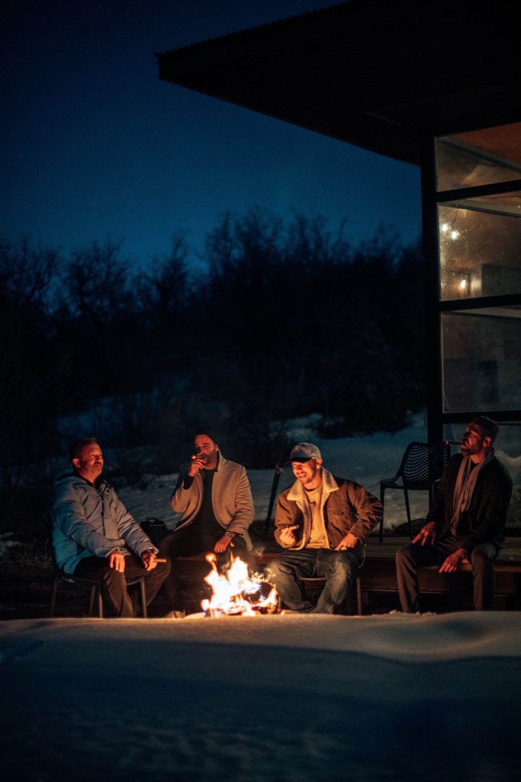 Members sharing a conversation beside a fire at night
